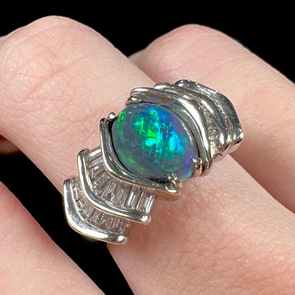 A white gold ring set with a Lightning Ridge natural black opal and baguette cut diamonds.