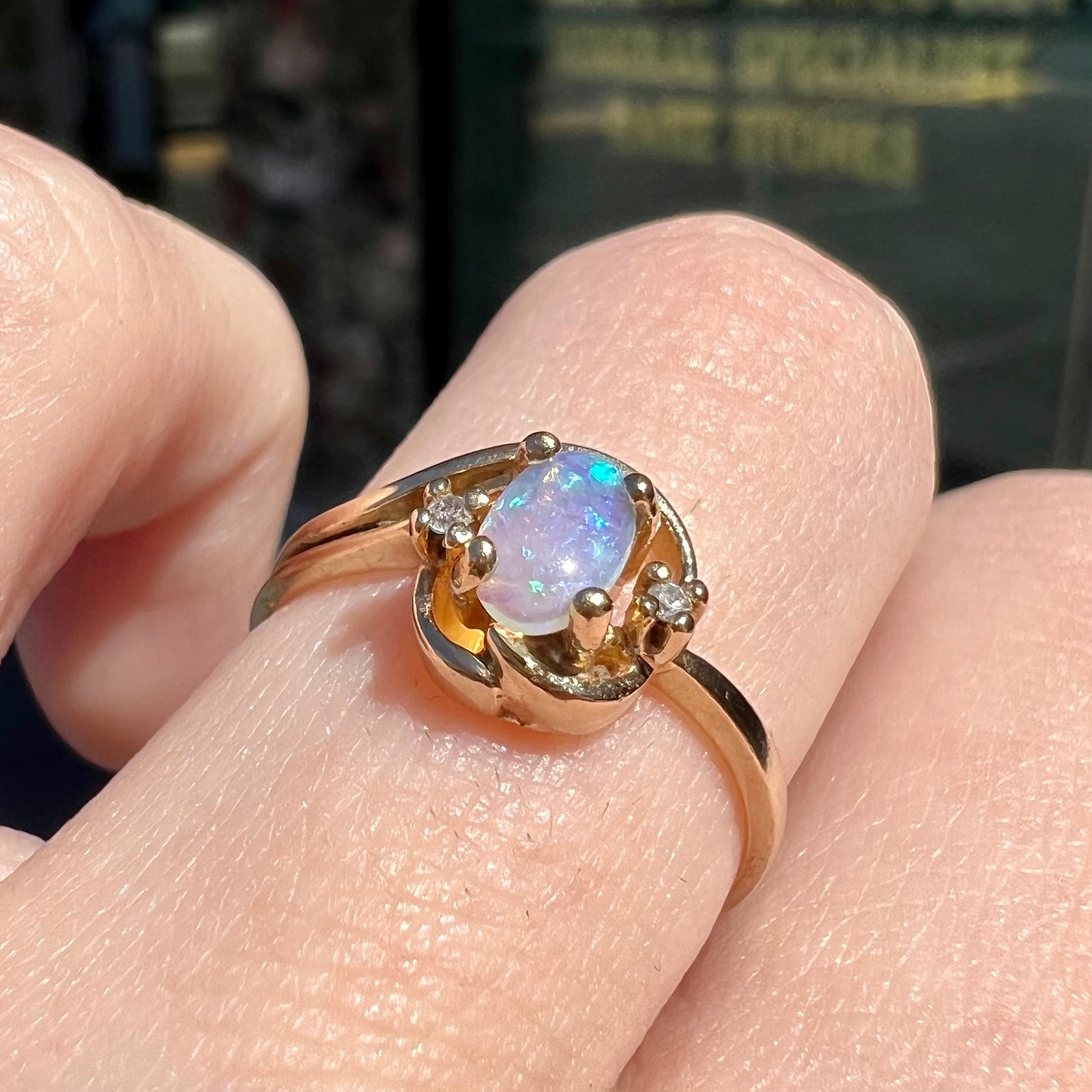 A dainty ladies' yellow gold opal and diamond accent ring.