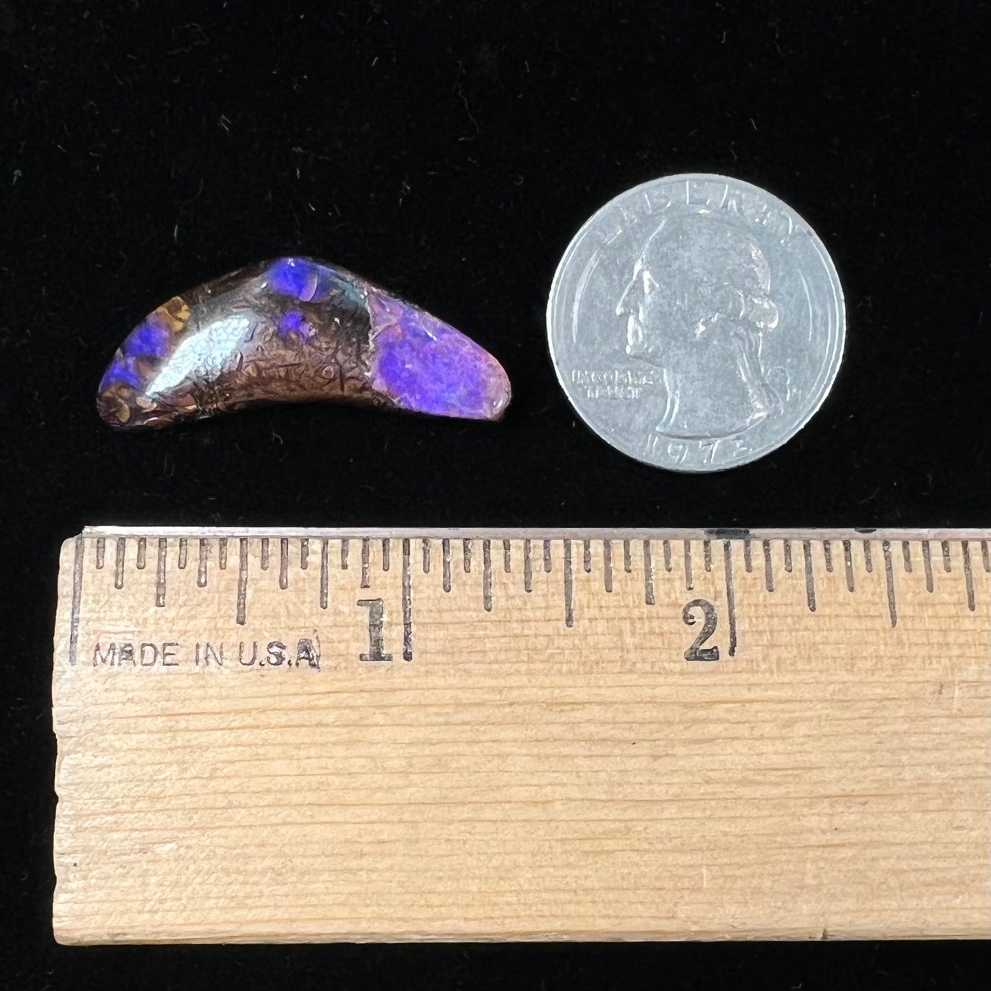 A loose boomerang shaped purple boulder opal stone from Quilpie, Australia.