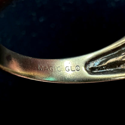 An inscription inside the bottom ring shank that reads "MAGIC GLO."