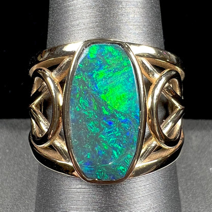 A men's natural Lightning Ridge, Australian black opal solitaire ring cast in yellow gold.