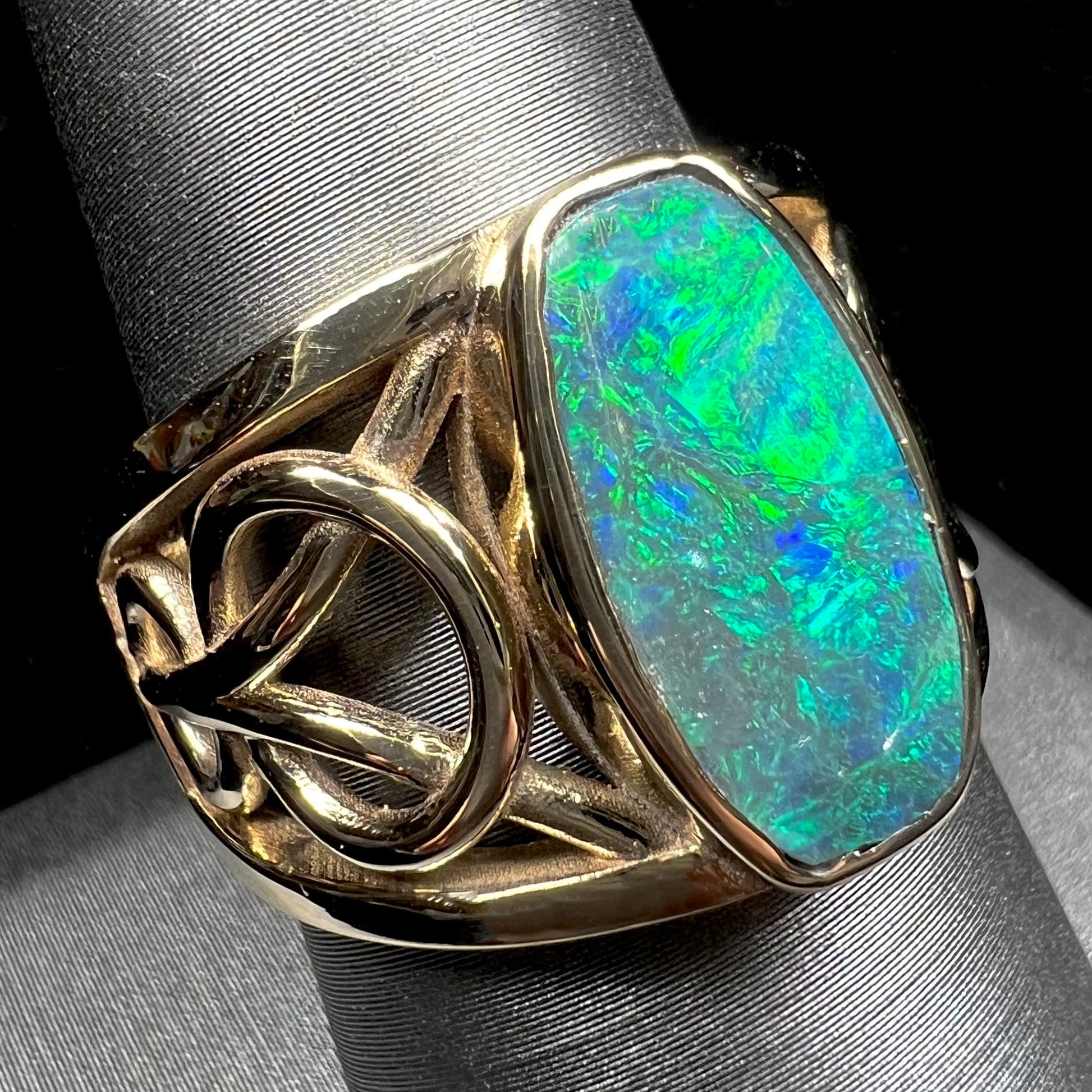 A men's natural Lightning Ridge, Australian black opal solitaire ring cast in yellow gold.