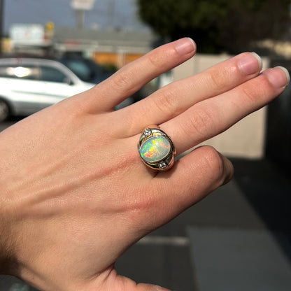 A yellow gold men's opal ring set with princess cut white sapphires.