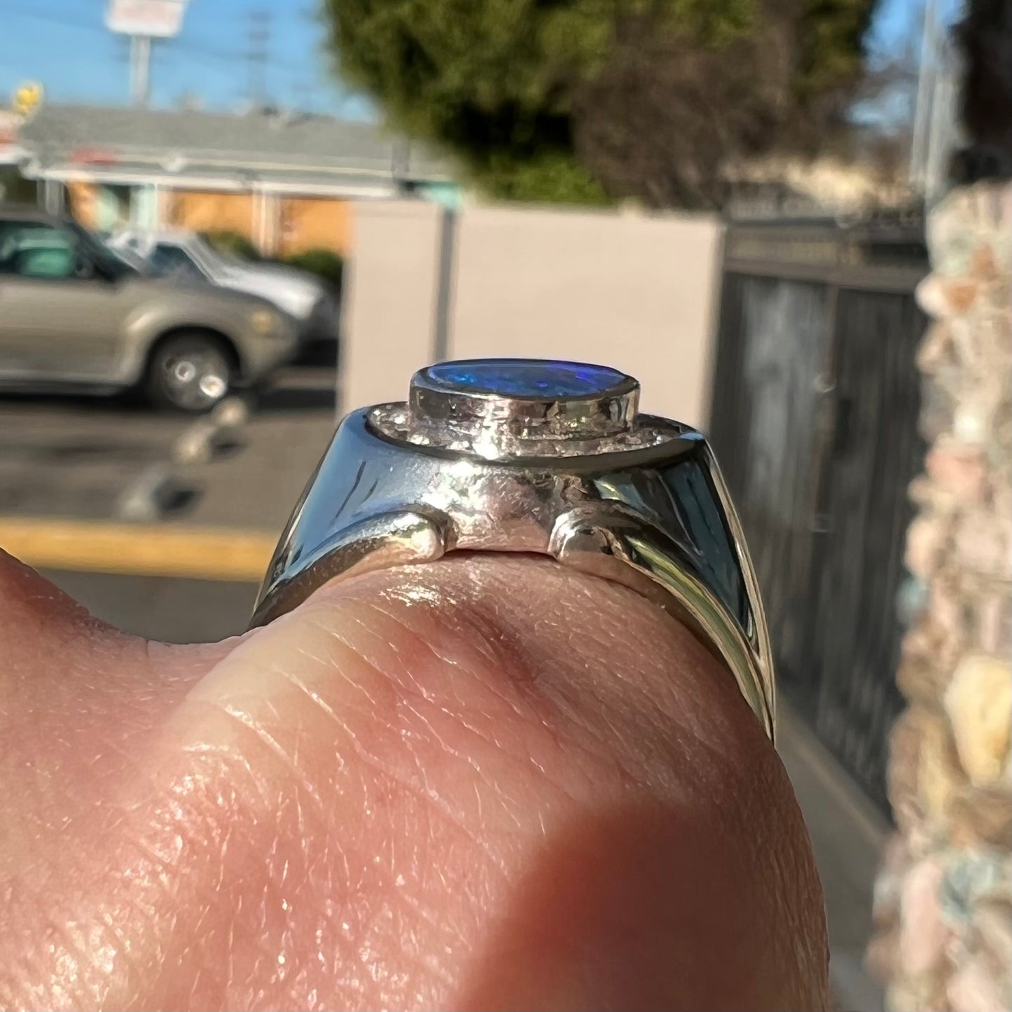 A men's black crystal opal and diamond halo ring in white gold.