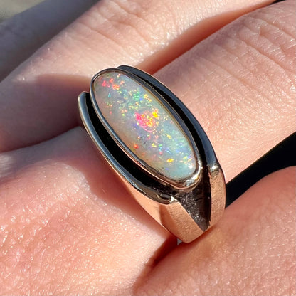 An Australian white crystal opal men's ring in solid yellow gold.  The recesses of the ring have been blackened.