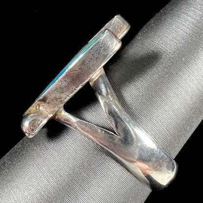 A turquoise, coral, and mother of pearl stone inlay ring made in the motif of a Zuni Indian headdress.