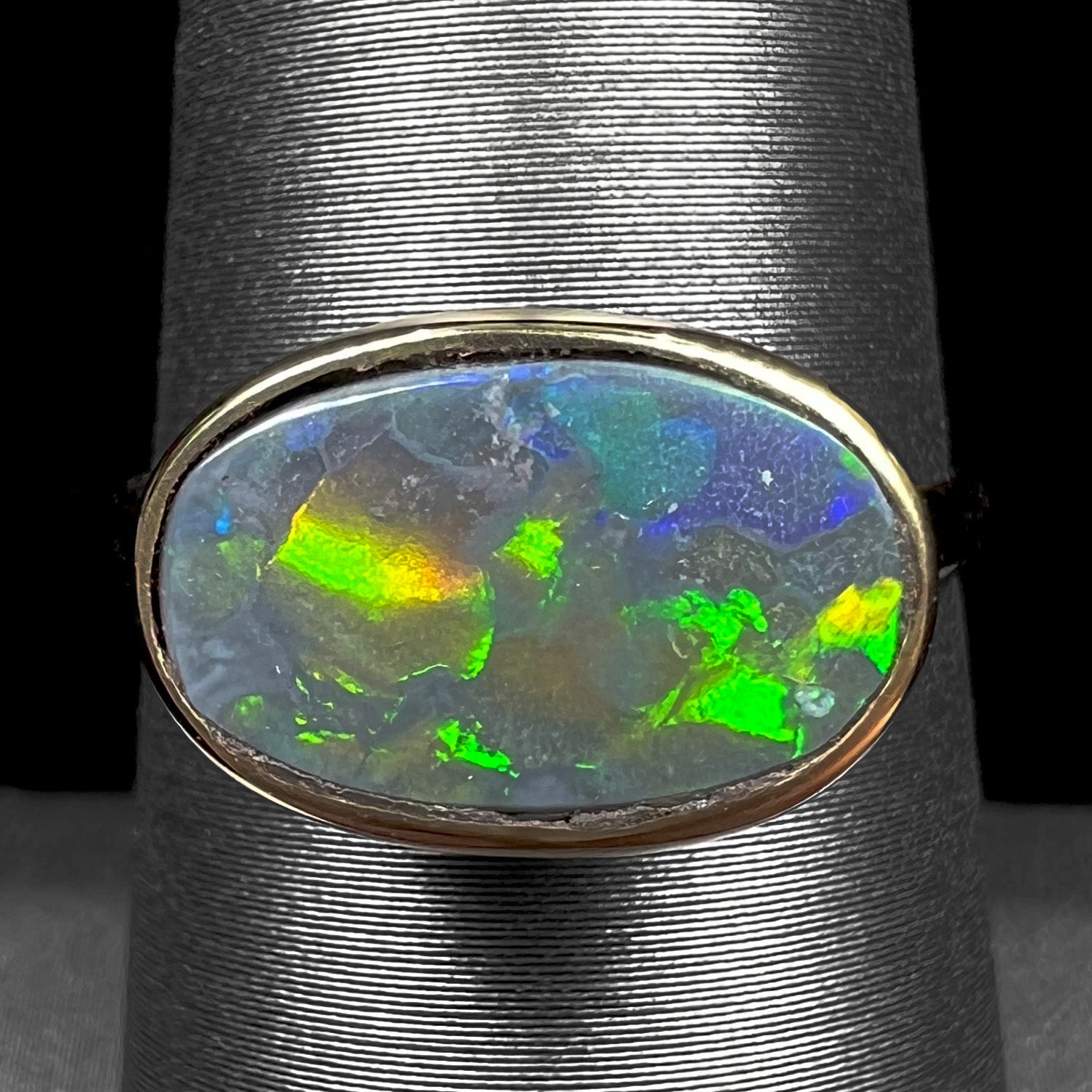 A ladies' yellow gold black opal solitaire ring from Lightning Ridge, Australia.