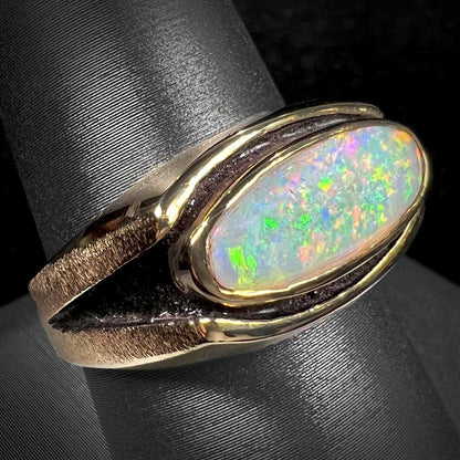 An Australian white crystal opal men's ring in solid yellow gold.  The recesses of the ring have been blackened.