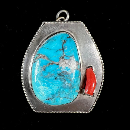 A sterling silver turquoise and polished coral branch pendant.  The back of the piece is signed "A.H."