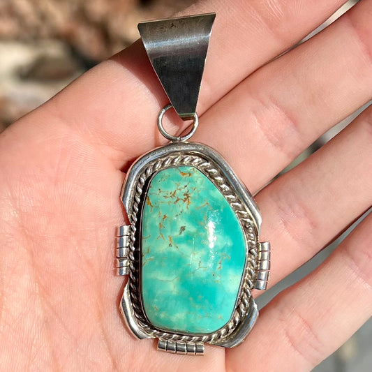 A men's silver Navajo pendant set with a turquoise stone from Pilot Mountain Mine, Nevada.