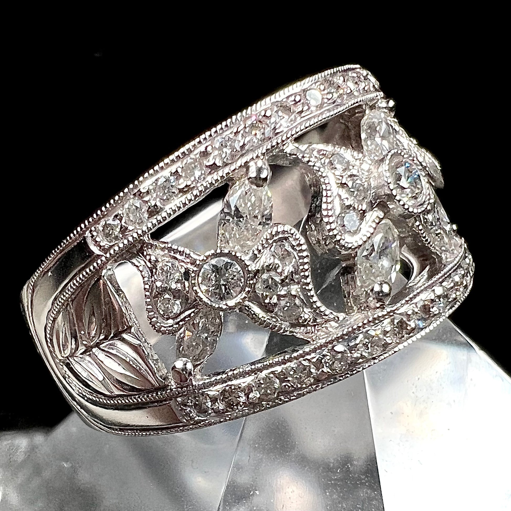 An art nouveau style 18k white gold ring set with round and marquise cut diamonds.