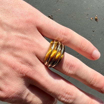 A ladies' high dome carved tiger's eye ring cast in yellow gold.