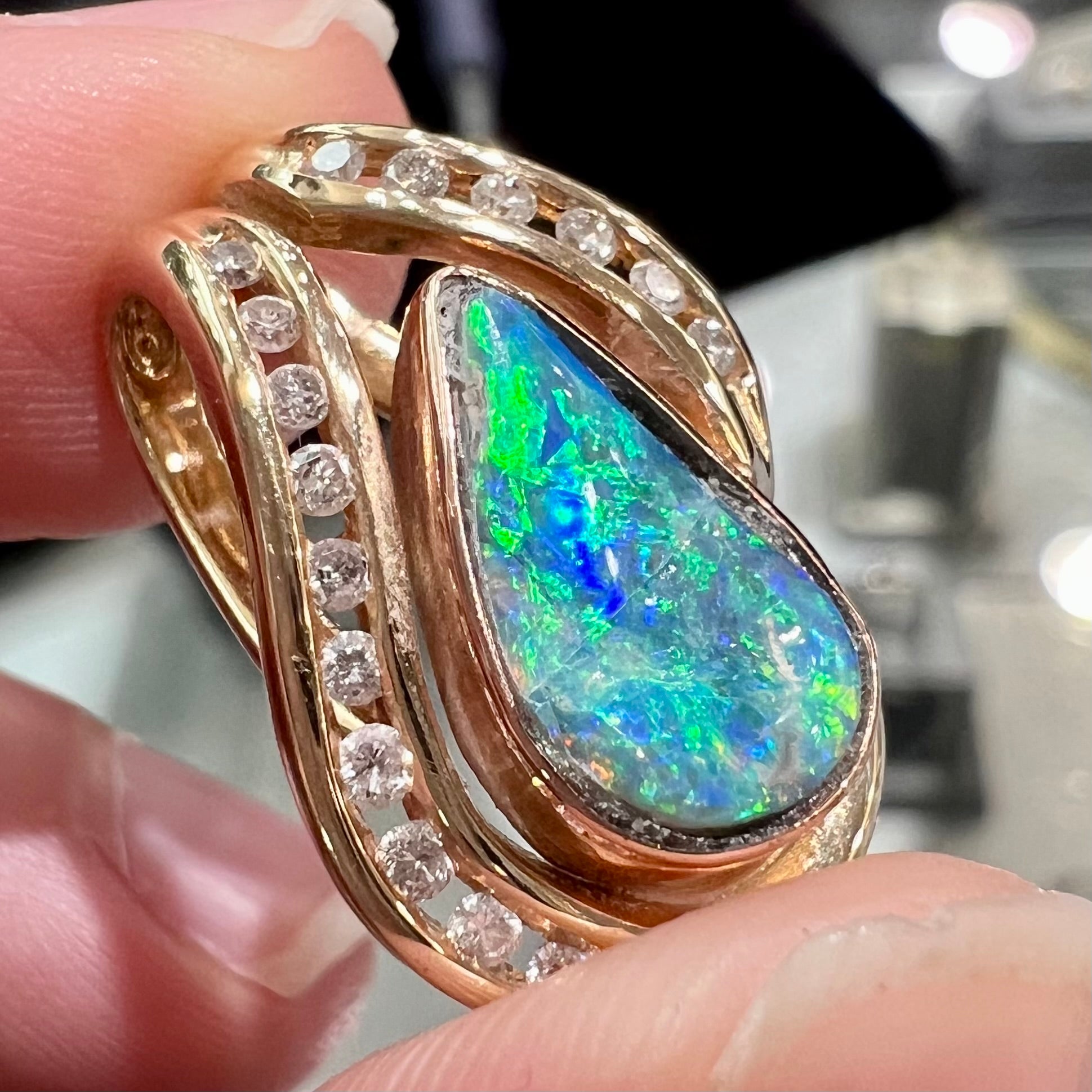 A ladies' yellow gold slider pendant set with a pear shaped Lightning Ridge, Australian black crystal opal and diamonds.