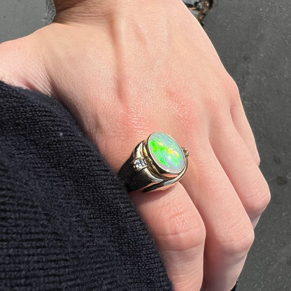 A yellow gold men's opal ring set with princess cut white sapphires.