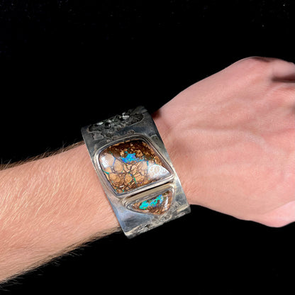 A men's sterling silver and copper infused cuff bracelet set with two boulder opal stones from Koroit, Australia.