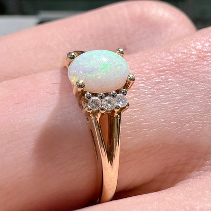 A ladies' yellow gold Coober Pedy, Australian opal ring set with three round cut diamonds.