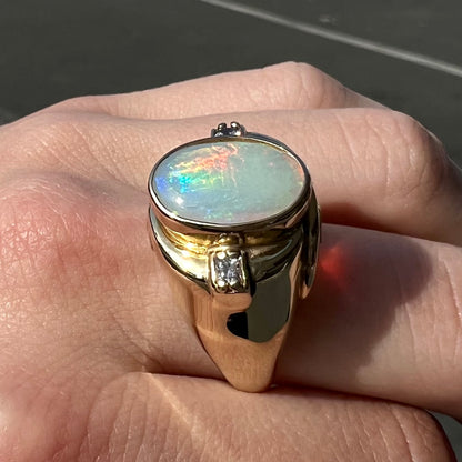 A yellow gold men's opal ring set with princess cut white sapphires.