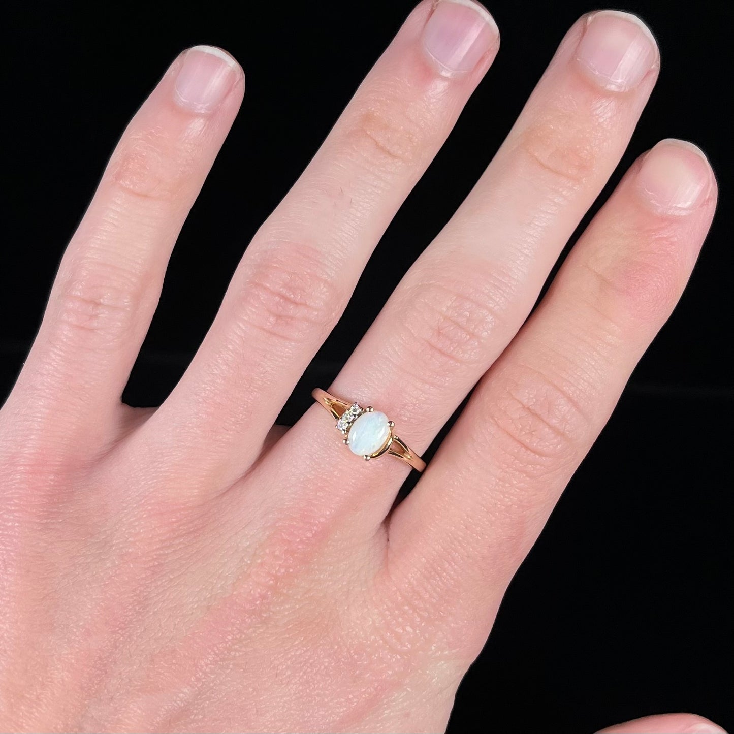 A ladies' yellow gold Coober Pedy, Australian opal ring set with three round cut diamonds.