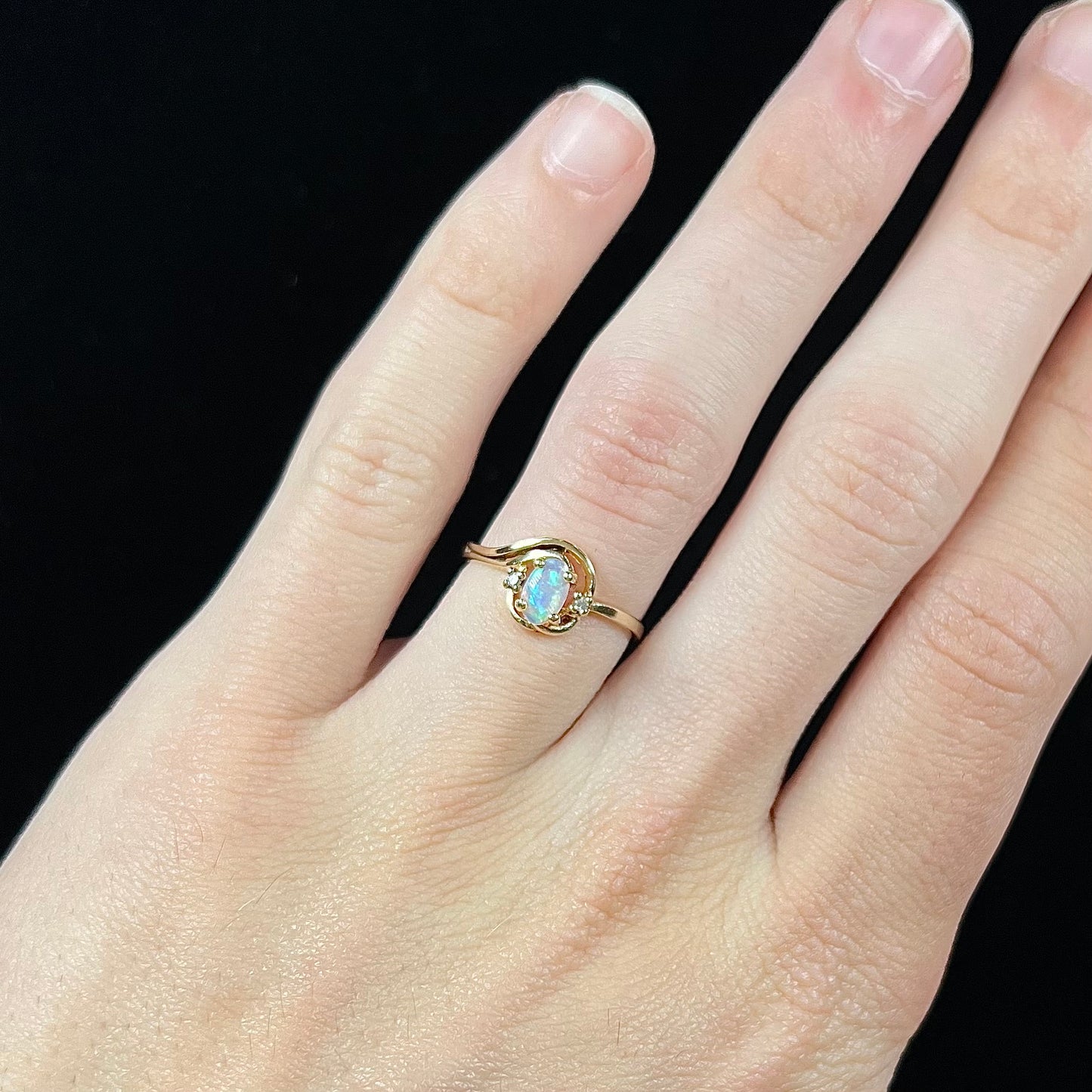 A dainty ladies' yellow gold opal and diamond accent ring.