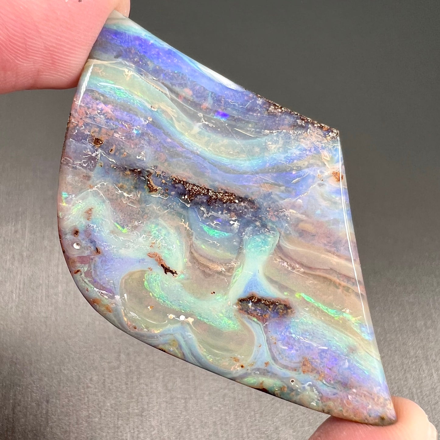 A polished boulder opal stone from Queensland, Australia.