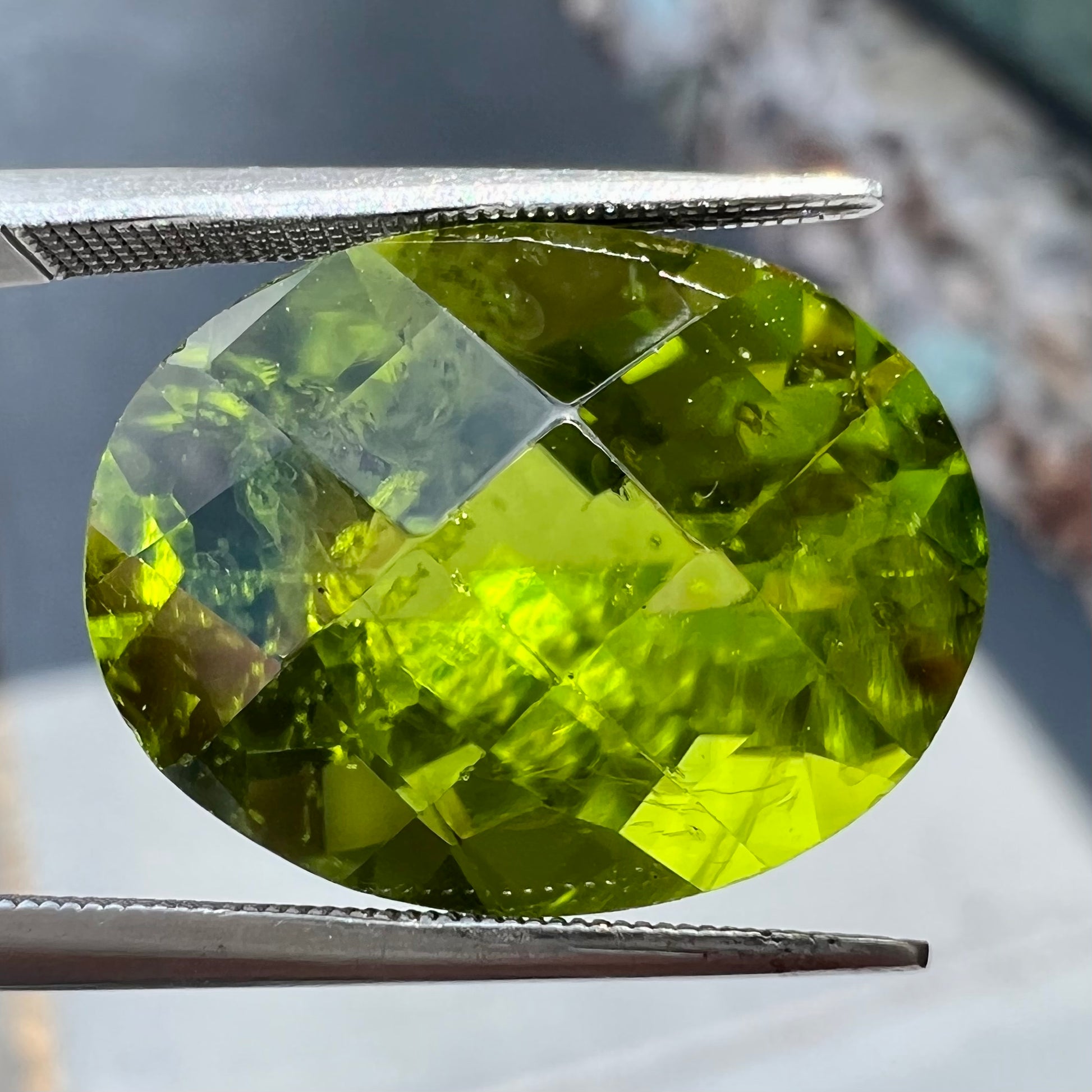 A loose, faceted oval checkerboard cut peridot gemstone from Pakistan.