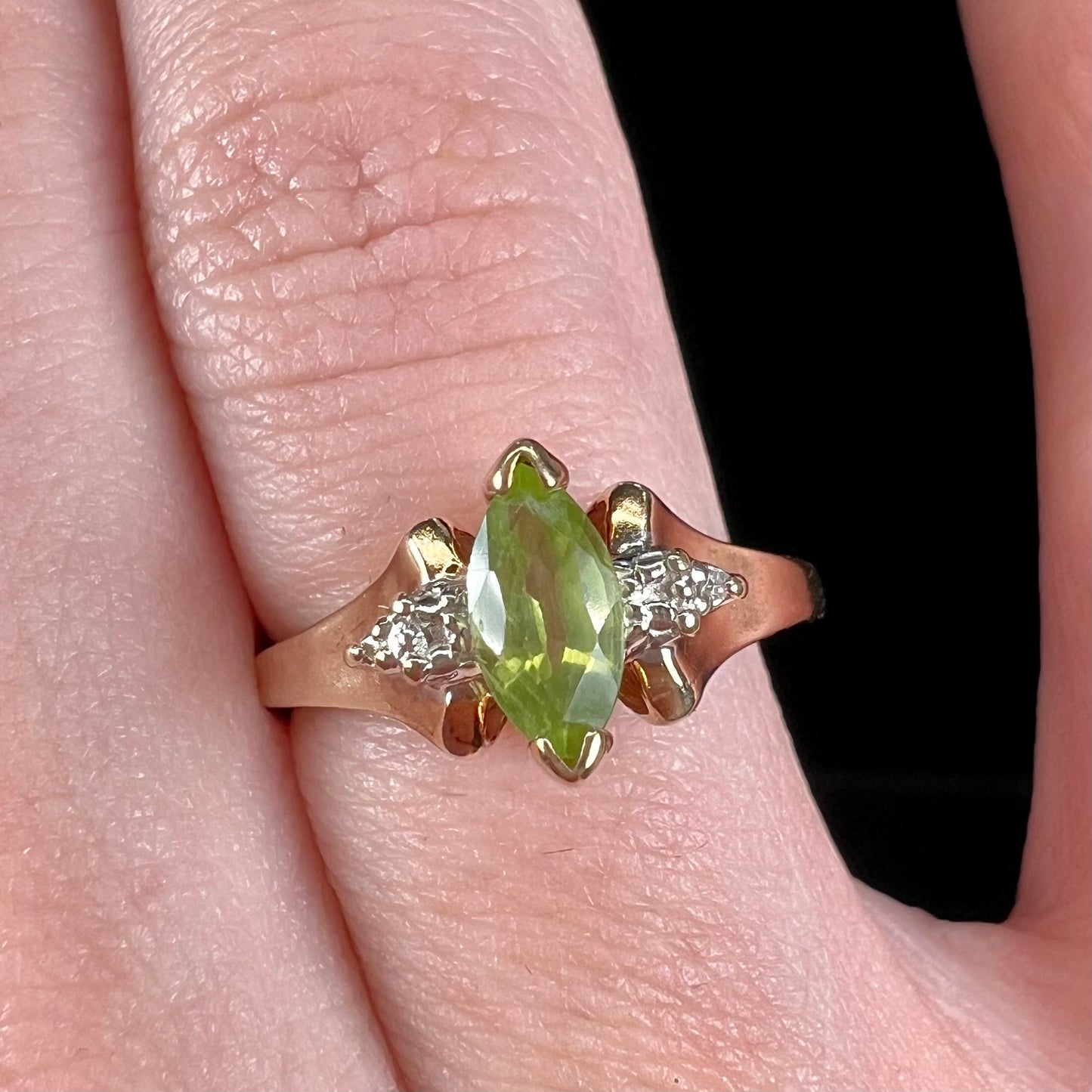 A ladies' marquise cut peridot and diamond ring in 10 karat yellow gold.