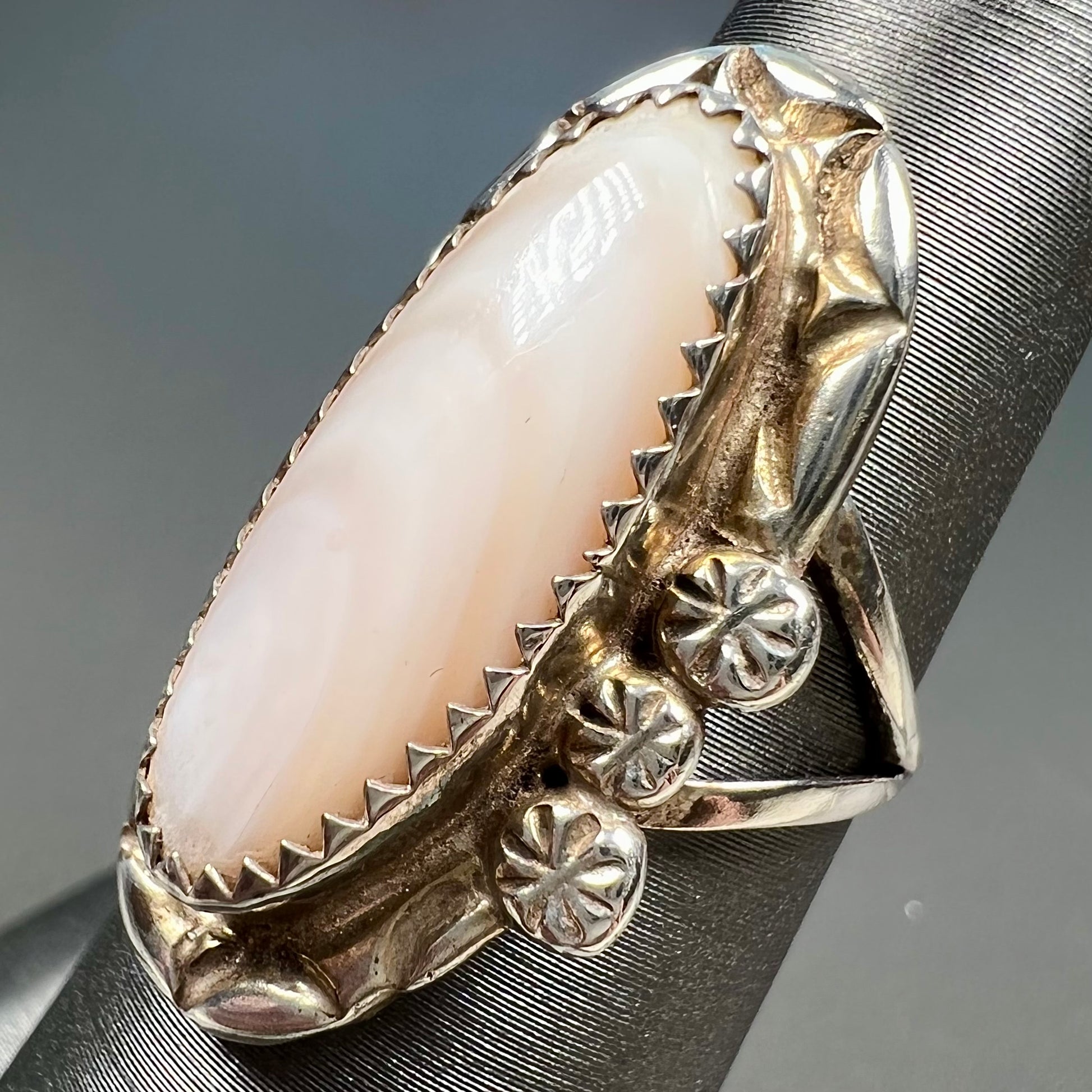 A Southwest style silver ring set with a faint pink mother of pearl stone.