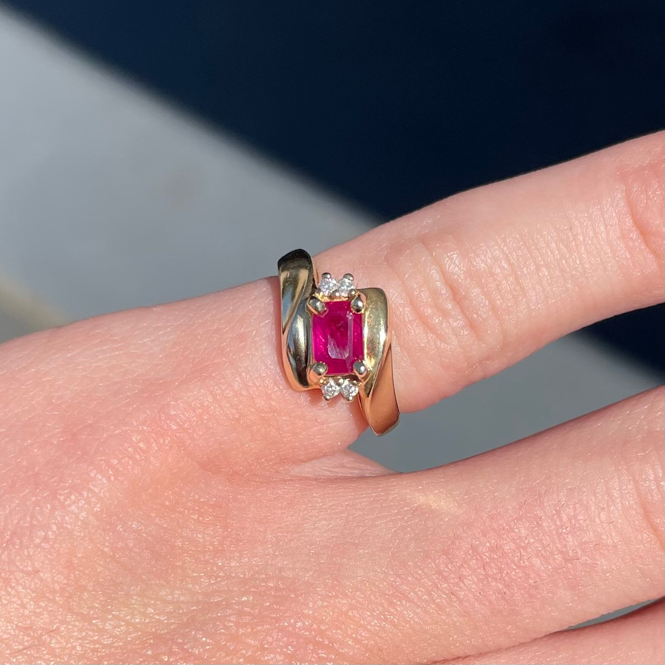 Emerald cut Burma ruby and diamond ring set in 14 karat yellow gold.