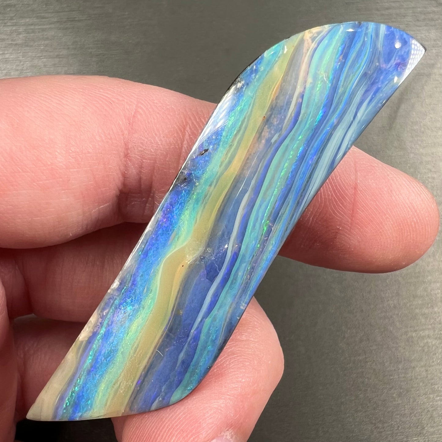 A large, loose, polished Quilpie boulder opal stone from Queensland, Australia.  The stone is blue.