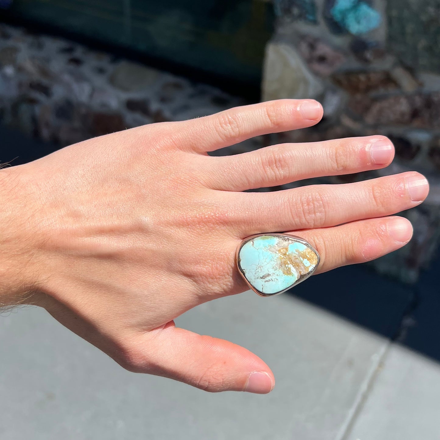 A men's sterling silver ring set with a powder blue turquoise stone.  The ring is rustic style.