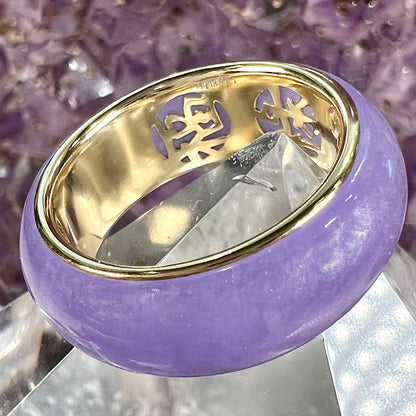 A stone ring carved from purple jadeite jade and mounted on a gold band.