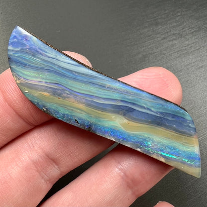 A large, loose, polished Quilpie boulder opal stone from Queensland, Australia.  The stone is blue.