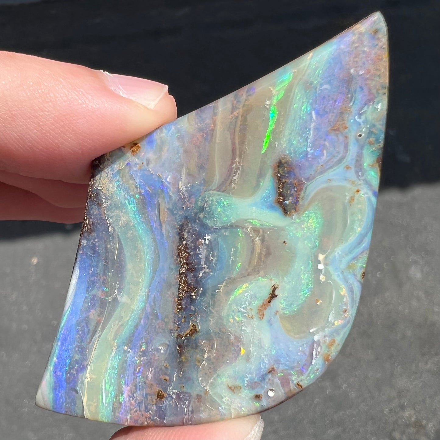 A polished boulder opal stone from Queensland, Australia.