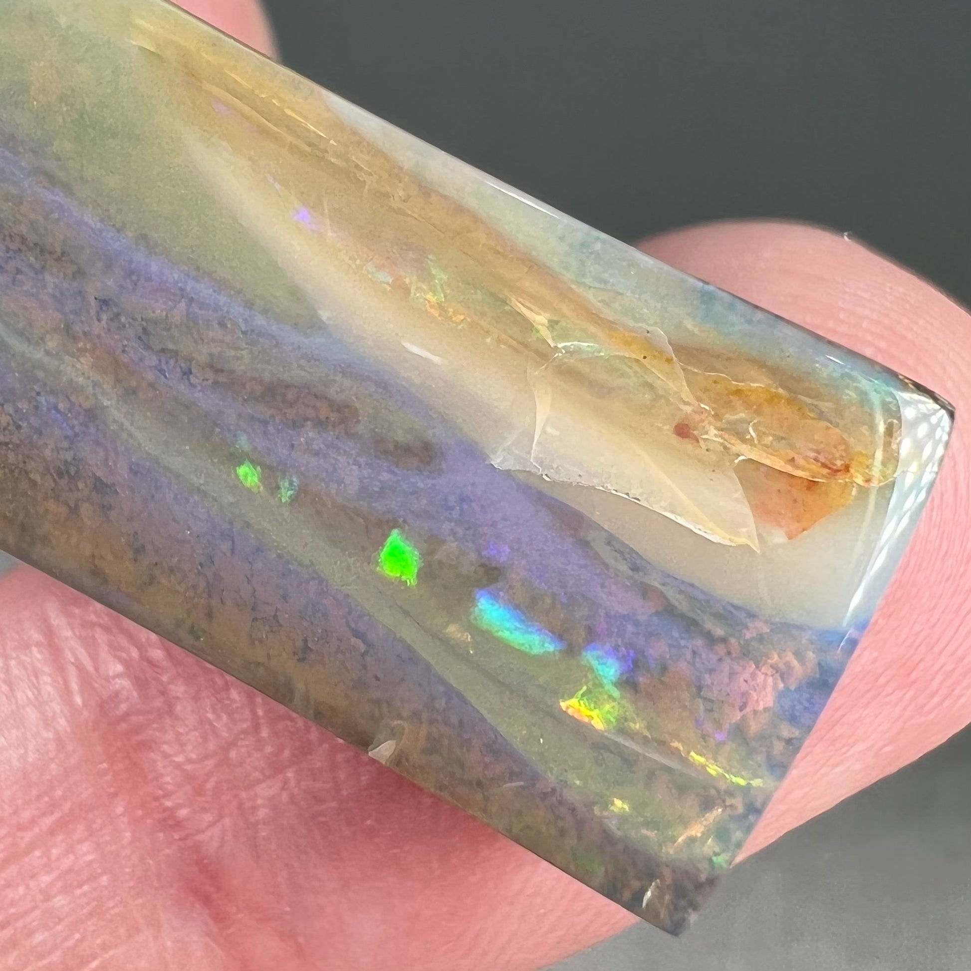 A polished, tapered rectangular cut boulder opal stone from Quilpie, Australia.