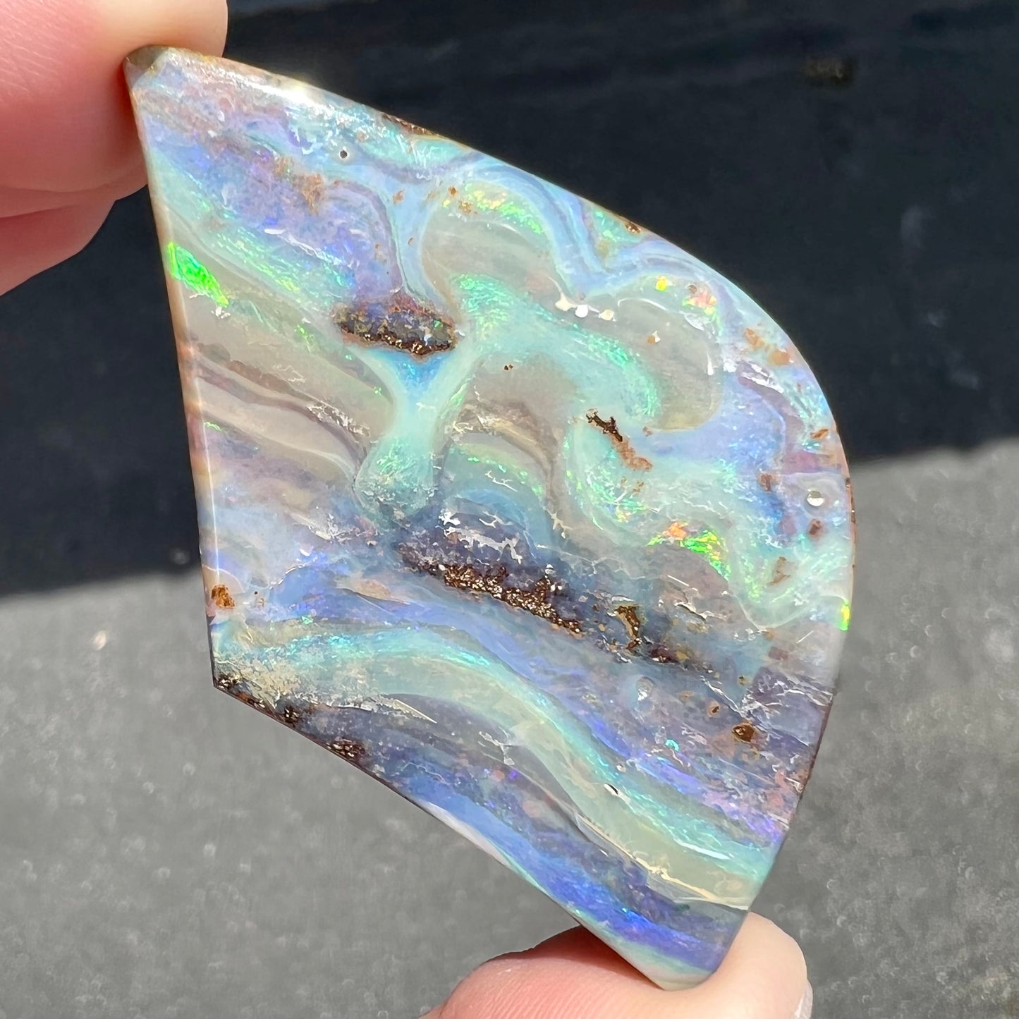 A polished boulder opal stone from Queensland, Australia.