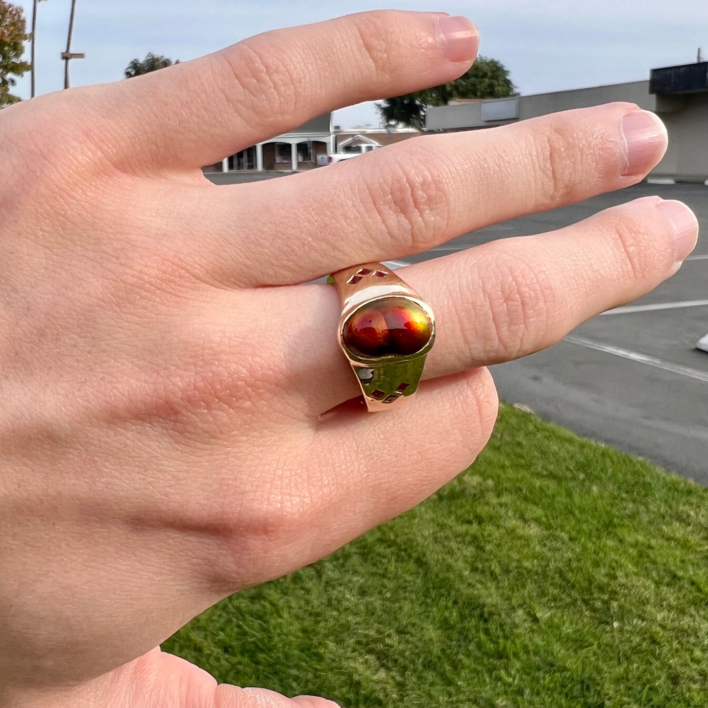 A yellow gold men's ring set with princess cut Burma rubies and a freeform cabochon cut red fire agate from Slaughter Mountain, Arizona.