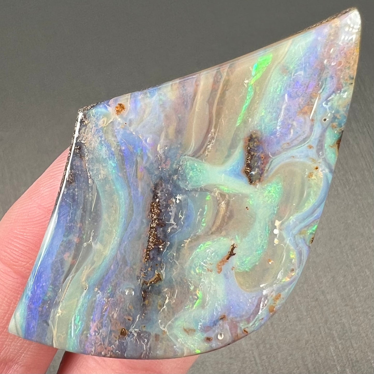 A polished boulder opal stone from Queensland, Australia.