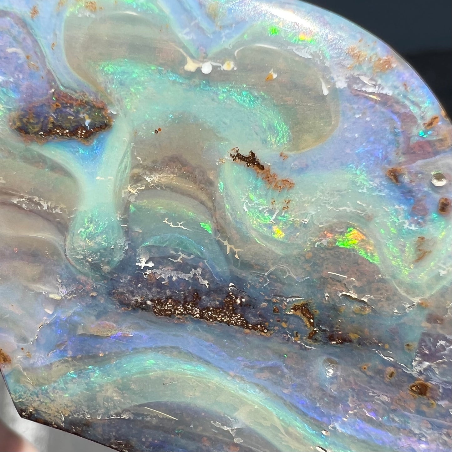 A polished boulder opal stone from Queensland, Australia.