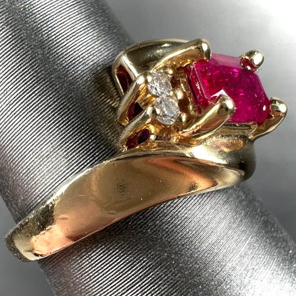 Emerald cut Burma ruby and diamond ring set in 14 karat yellow gold.