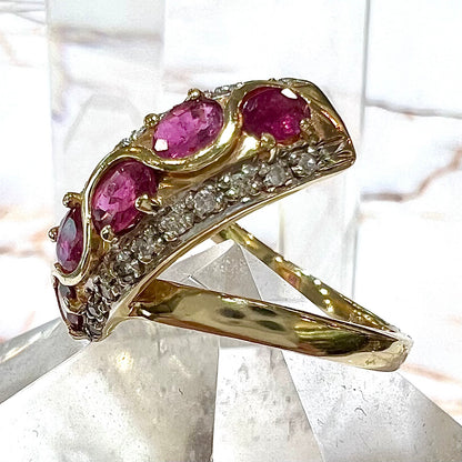 A custom freeform design yellow gold twisted shank ring set with five oval cut rubies and small round diamonds.