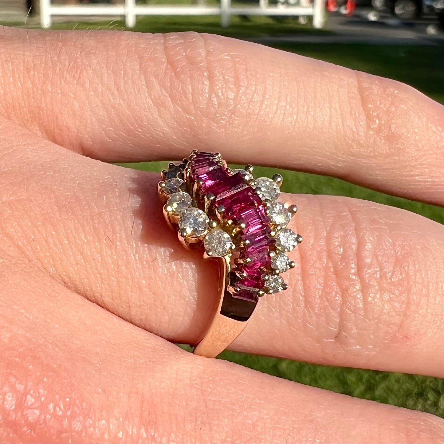 A yellow gold ladies' ring set with 12 baguette cut rubies and 12 Standard Round Brilliant Cut diamonds.