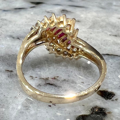 A yellow gold ladies' ring set with 12 baguette cut rubies and 12 Standard Round Brilliant Cut diamonds.