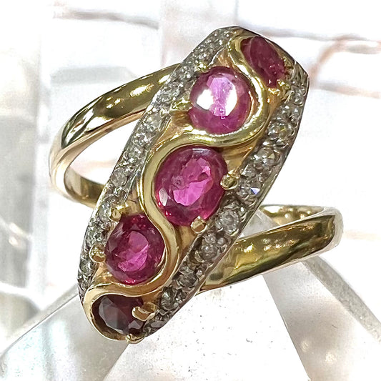 A custom freeform design yellow gold twisted shank ring set with five oval cut rubies and small round diamonds.