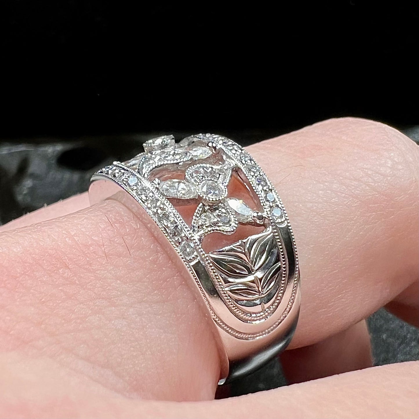 An art nouveau style 18k white gold ring set with round and marquise cut diamonds.