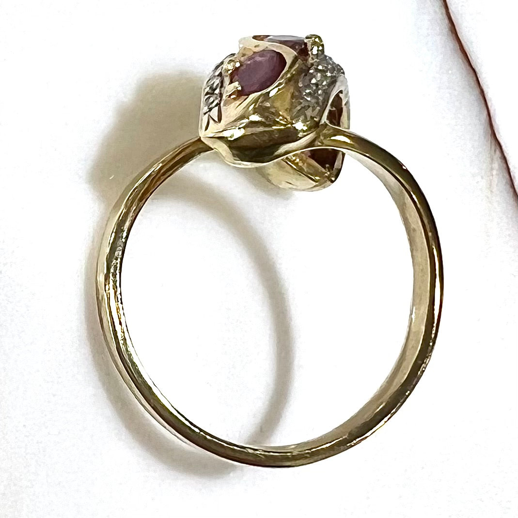 A custom freeform design yellow gold twisted shank ring set with five oval cut rubies and small round diamonds.