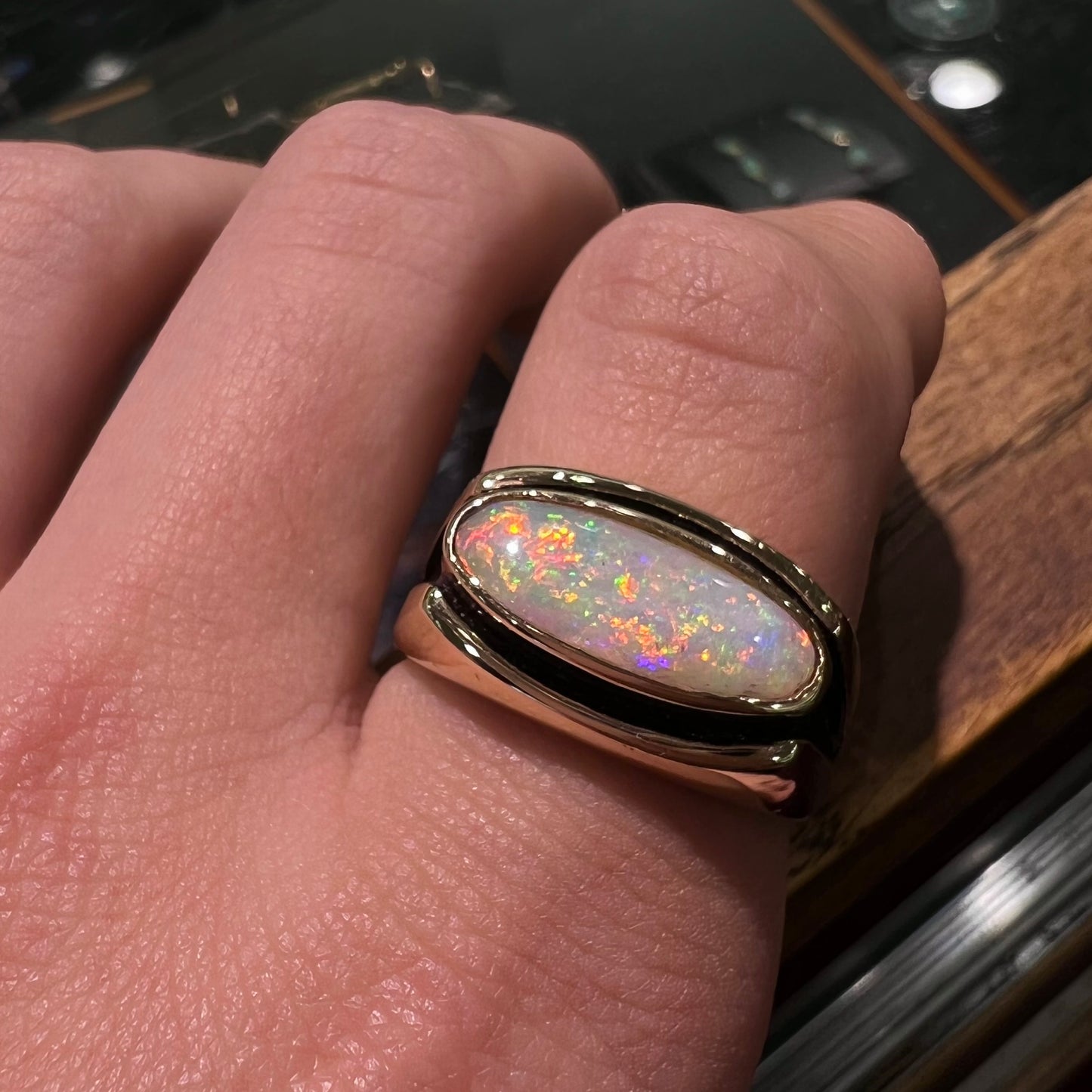 An Australian white crystal opal men's ring in solid yellow gold.  The recesses of the ring have been blackened.