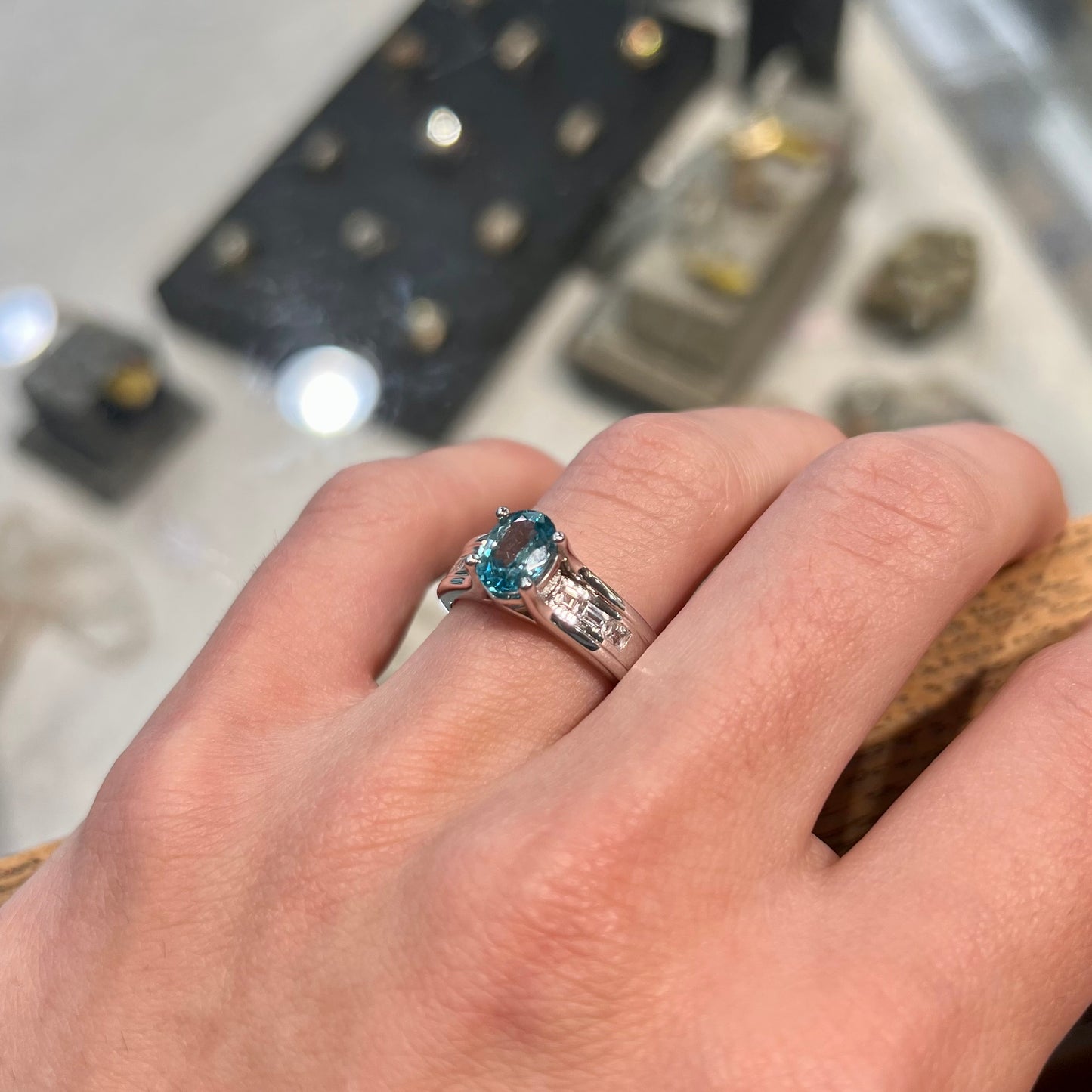 A sterling silver ring set with an oval cut blue zircon center stone and channel set white zircon accents.