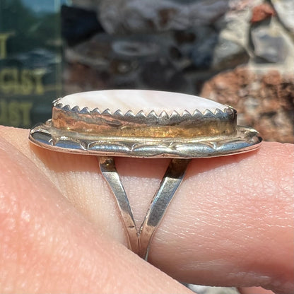 A Southwest style silver ring set with a faint pink mother of pearl stone.