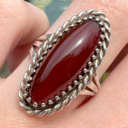 A split shank silver ring set with a brown sard stone in a rope bezel with small prongs.