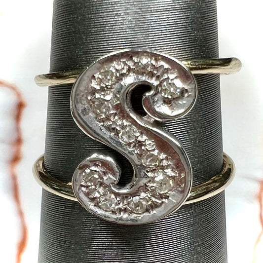 A two tone white and yellow gold initial ring of the letter "S" set with diamonds.